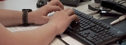 man sieht zwei Hände, die auf einer Computertastatur schreiben