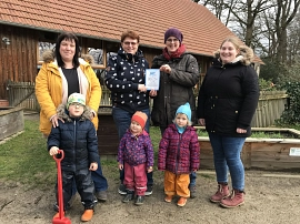 Die Leitung Eileen Dauer mit ihrem Kita-Schild  das Team vom Kindergarten Immenkorf aus Waffensen. © Landkreis Rotenburg (Wümme)