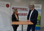 Iris Rheder und Marco Prietz im Gespräch vor zwei Rollups mit den Logos von Schule und Landkreis. © Landkreis Rotenburg (Wümme)