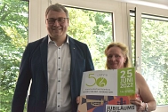 Landrat Marco Prietz und Meike Pesch mit einem Plakat zum 50-jährigen Jubiläum der Kreismusikschule. © Landkreis Rotenburg (Wümme)