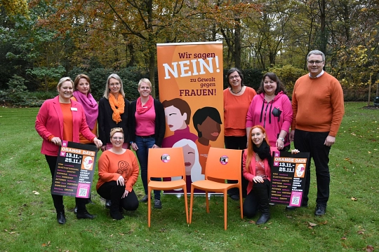 8 Frauen und ein Mann mit zwei orangefarbenen Stühlen und einem bunten Rollup. Alle tragen rosa und organgene Kleidung. © Landkreis Rotenburg (Wümme)